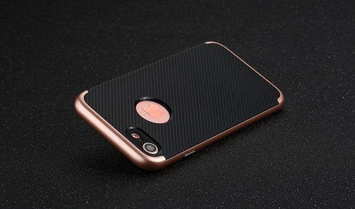 Phone case with rose gold edge and black back on a dark surface