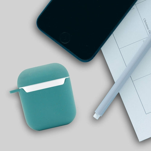 Teal case for wireless earbuds next to a smartphone and stylus on a light gray surface