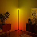 Modern floor lamp casting a warm glow in a room with furniture and decor.